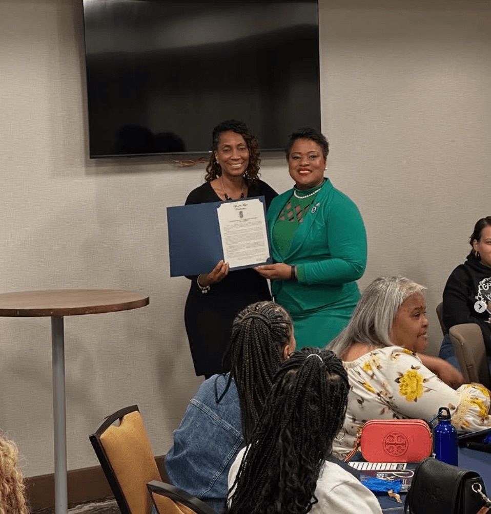IMPACT Sports representatives being recognized with a citation at a community meeting.